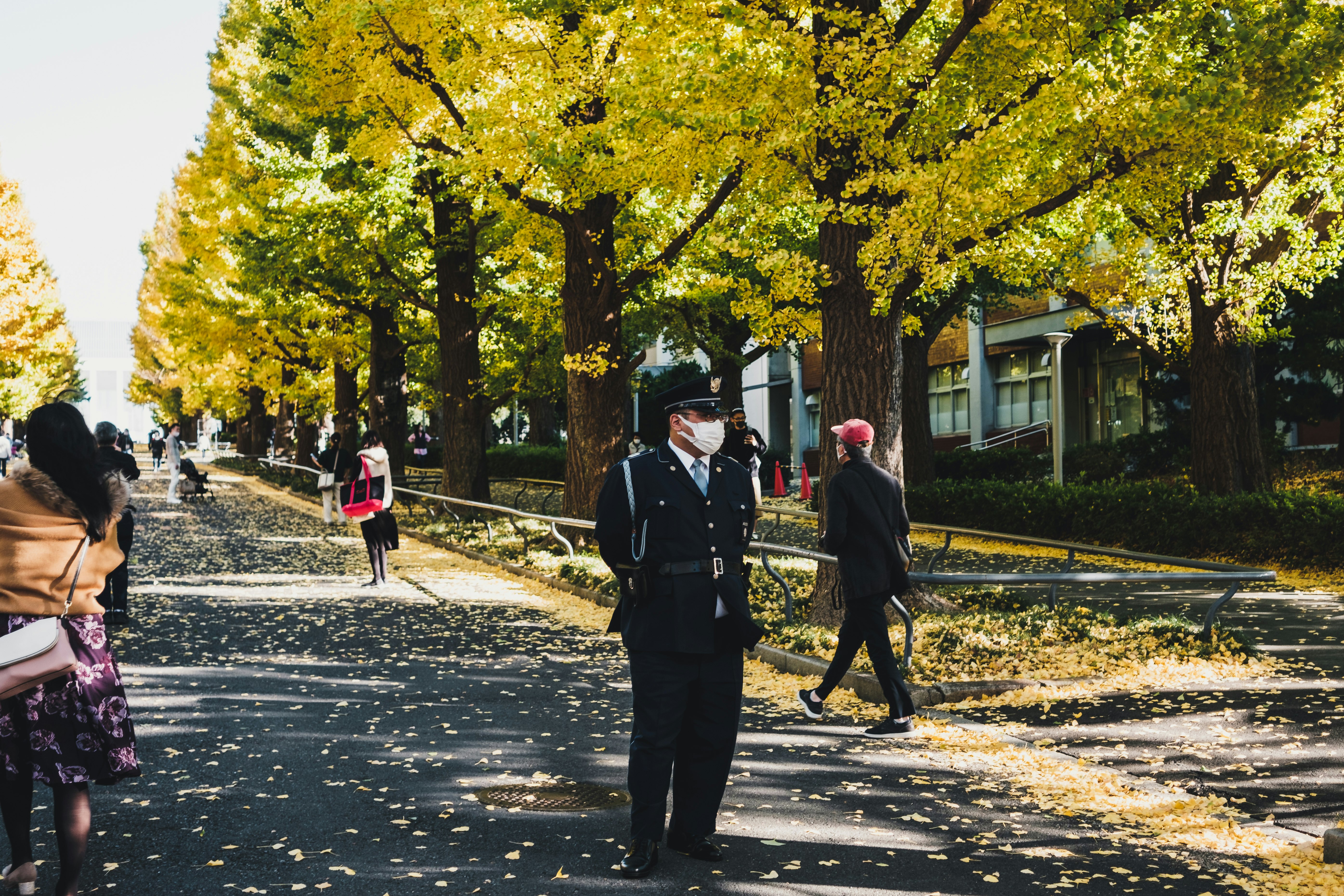 man in black coat walking on sidewalk during daytime